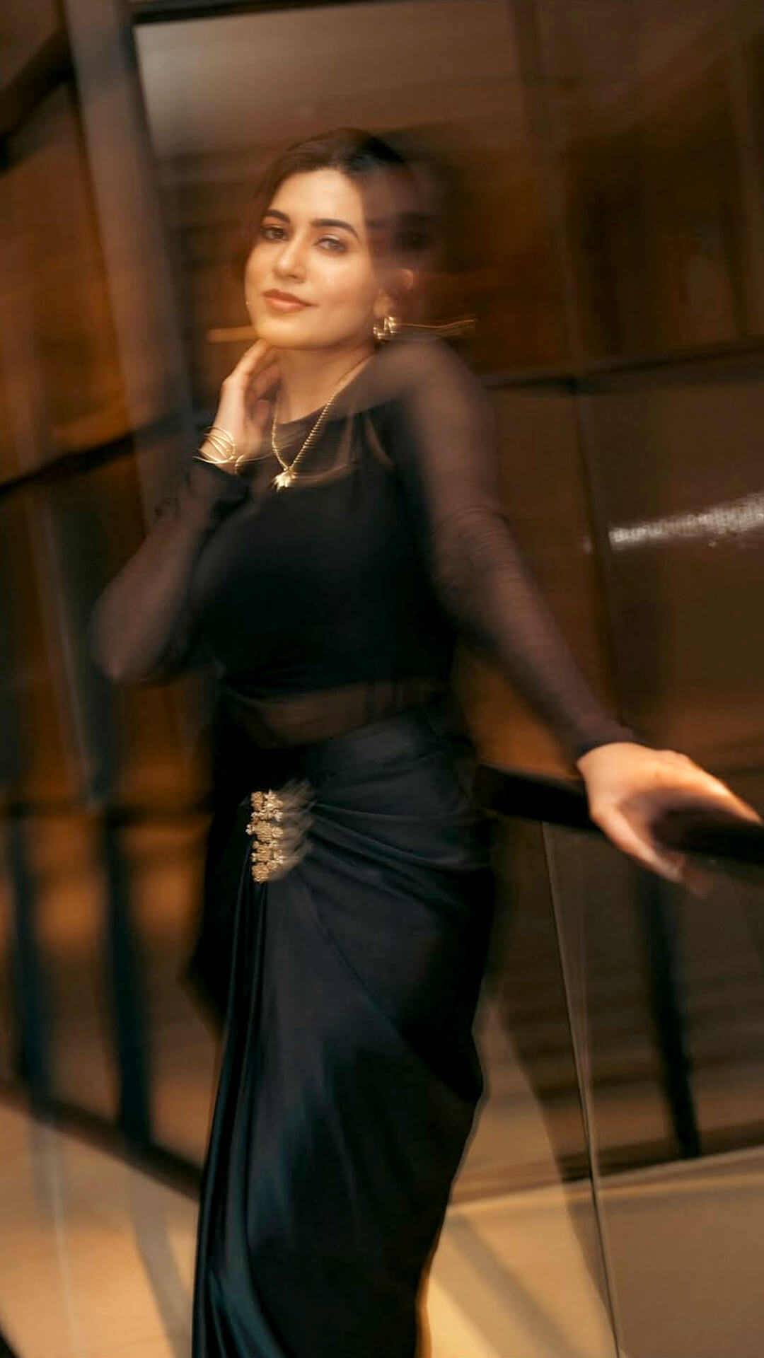 Anju Kurian's Recent Photoshoot - Captured by Lokesh Kumar, the photoshoot bathes Anju in warm light, reflecting the sheen of her black ensemble against a modern indoor backdrop.