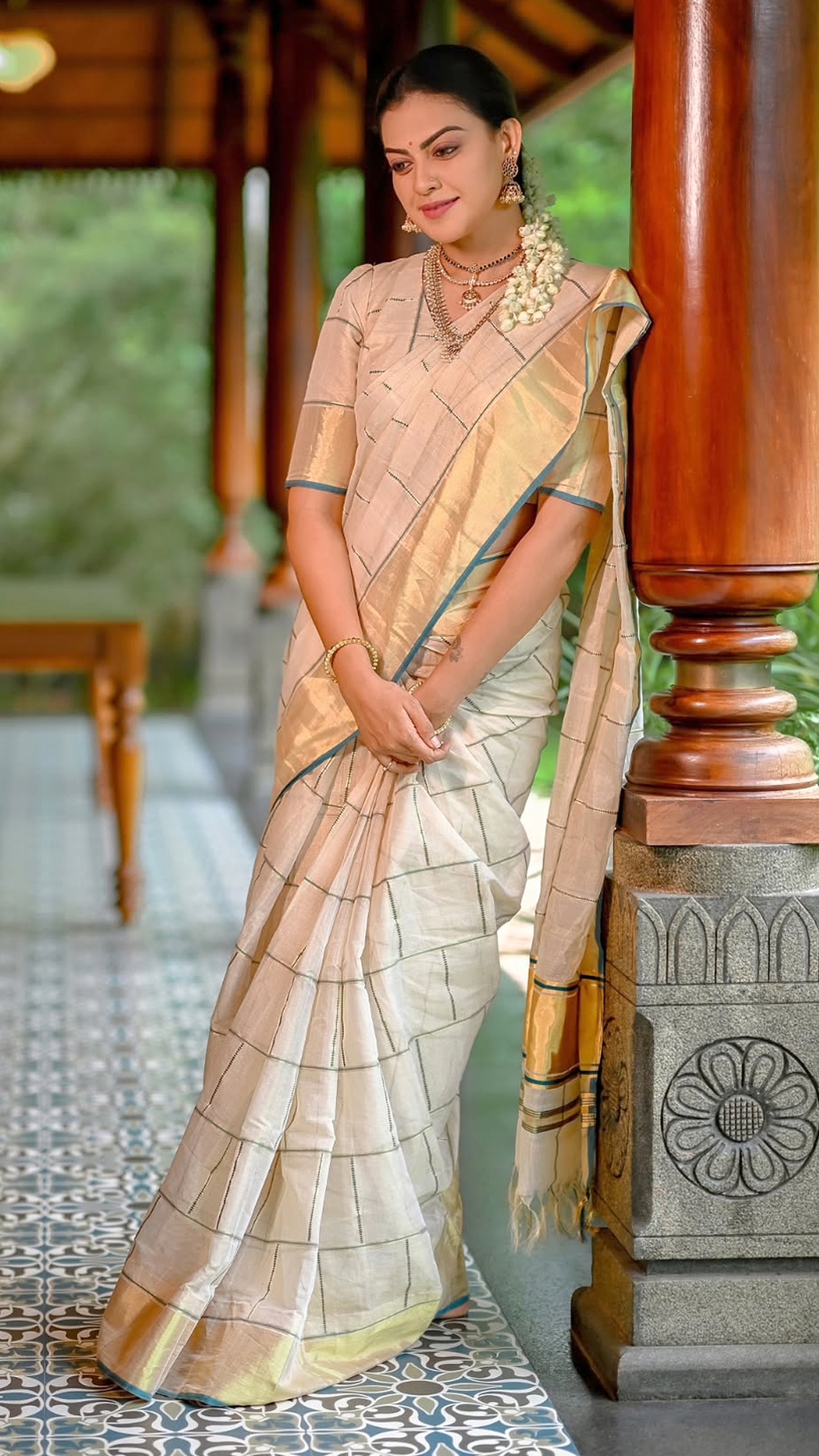 Anusree Nair's Recent Photoshoot - Soft ivory, luminous gold and a slim blue border create measured contrast. The restrained palette lets every woven detail remain easy to appreciate.