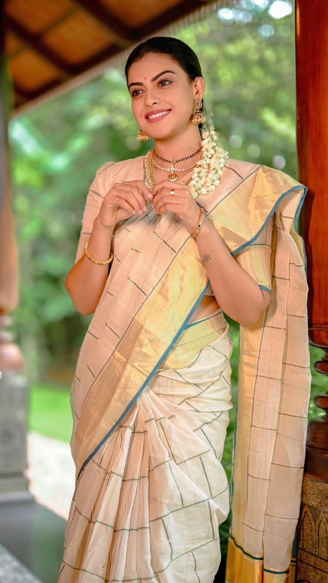 Anusree Nair's Recent Photoshoot - Jhumkas, layered necklaces, bangles and a small bindi echo the golden border, building visual continuity while allowing the handloom fabric to remain the focal point.