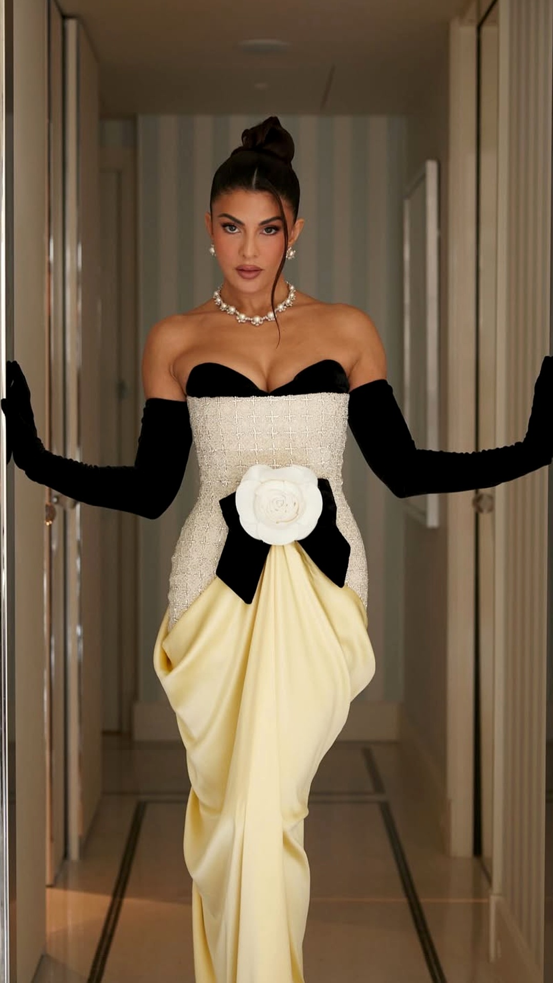 Jacqueline Fernandez's Recent Photoshoot - The lower portion features a pale butter-yellow shade, a smooth satin finish, and a gathered drape falling beautifully into a floor-length style.