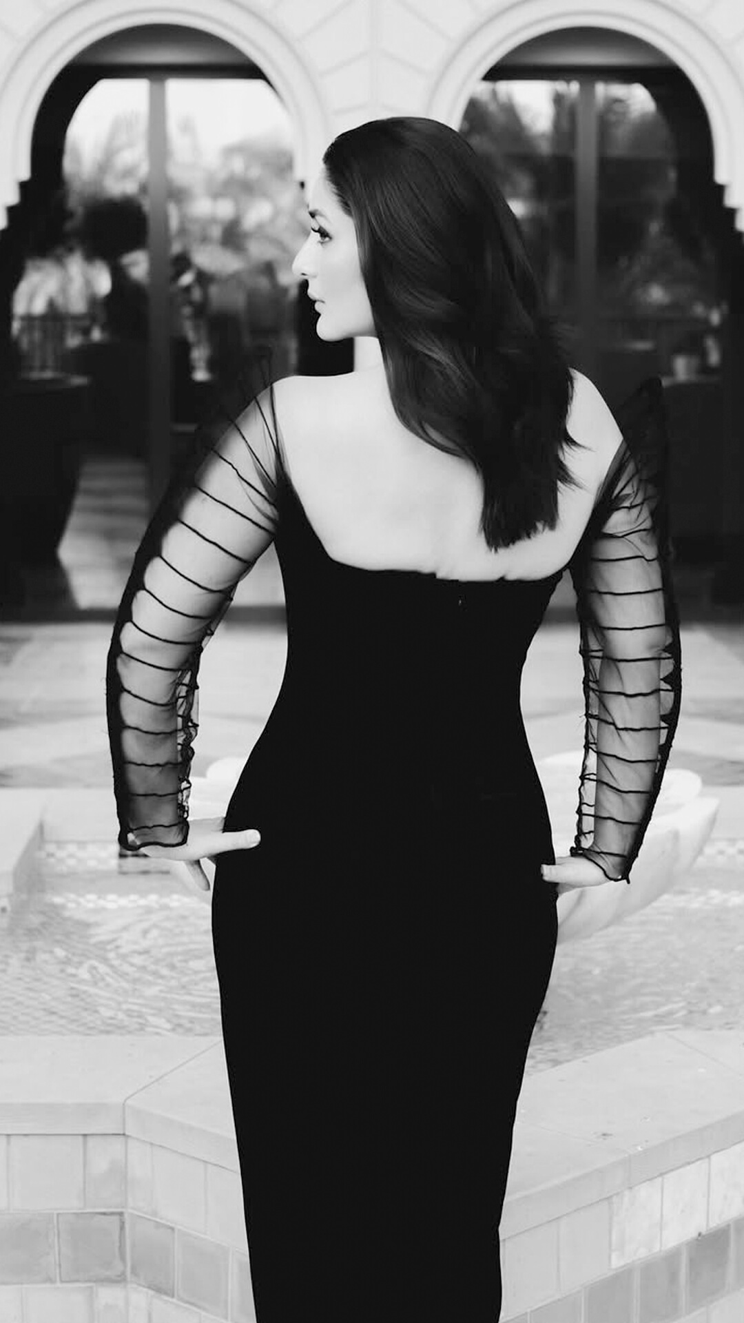 Kareena Kapoor's Recent Photoshoot - The gown’s open back design reveals a graceful silhouette. The sheer striped sleeves continue to the back, adding allure to her elegant bare-back moment.