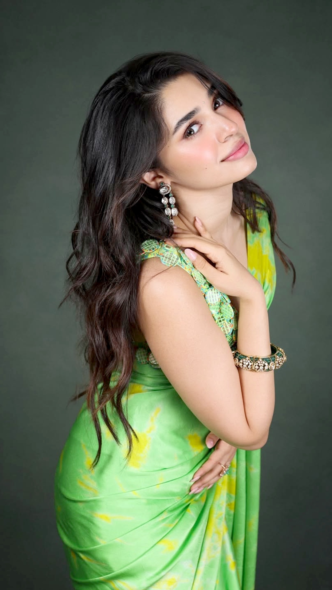 Krithi Shetty's Recent Photoshoot - Her long, side-parted waves fall naturally with volume, giving a soft finish that balances the bold blouse and bright tones.