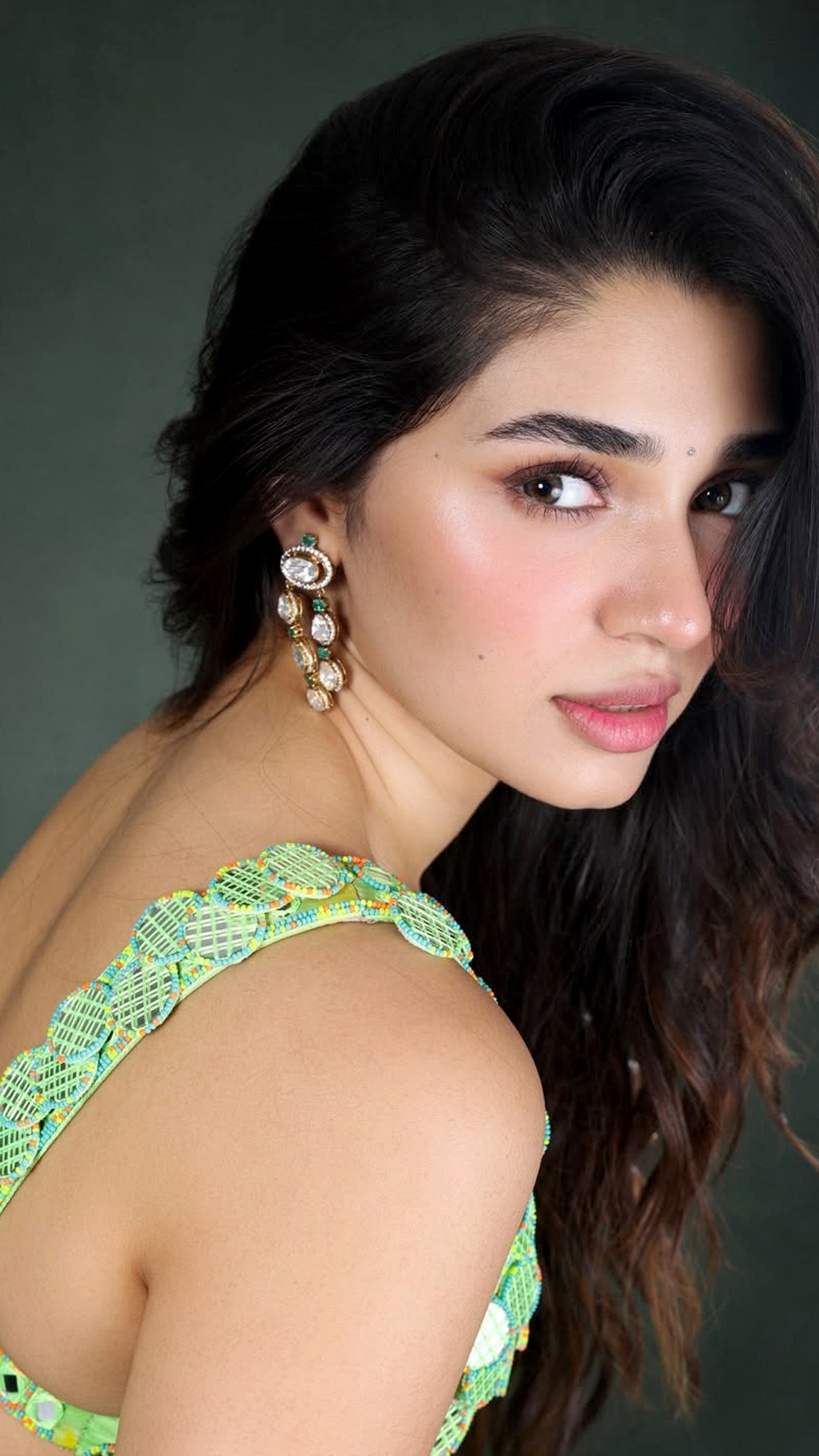 Krithi Shetty's Recent Photoshoot - The plunging neckline and sleeveless cut bring a modern edge, while the neat back hook detail keeps the look structured yet relaxed.