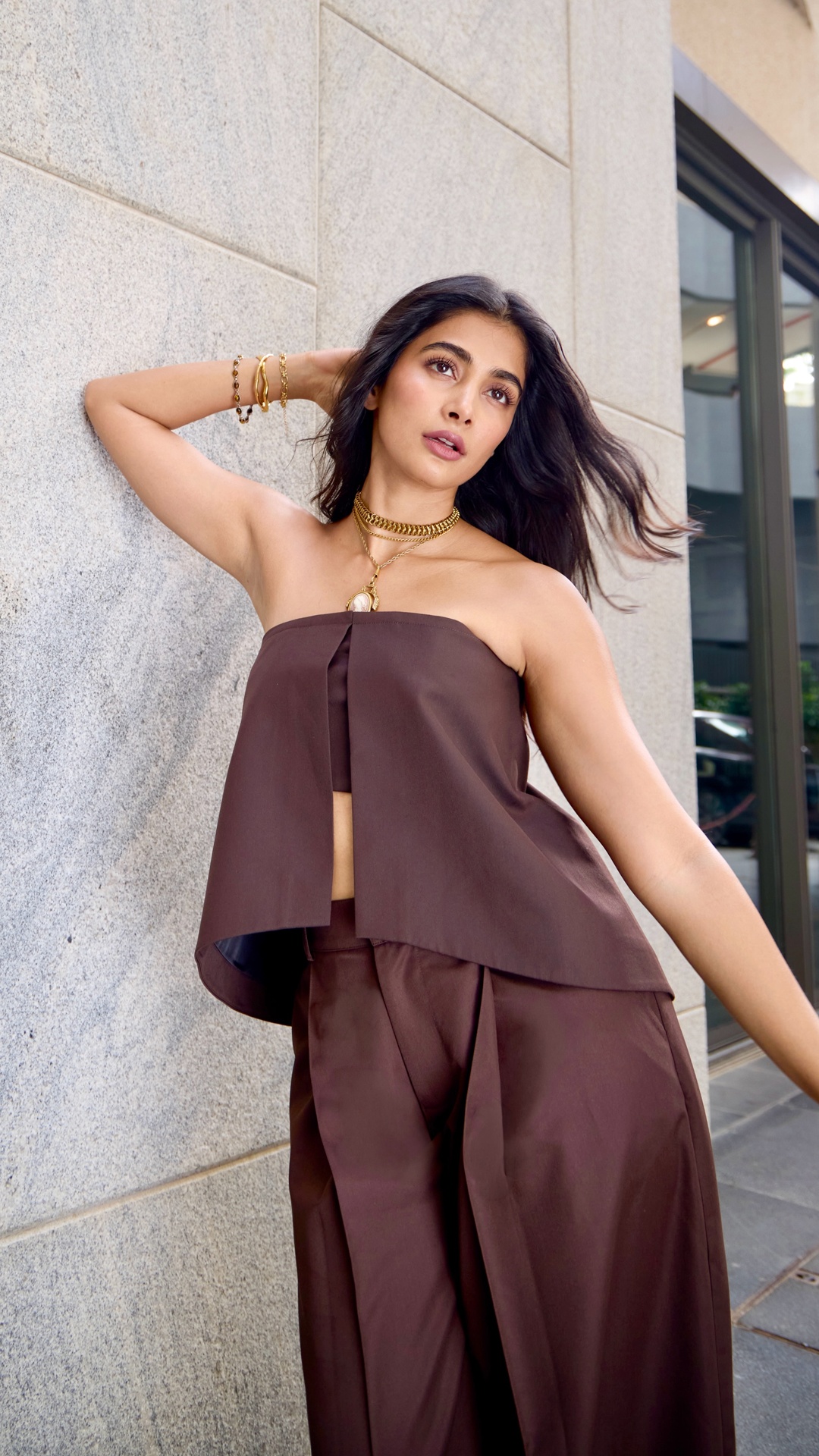 Pooja Hegde's Recent Photoshoot - BLSSD's chocolate-brown strapless top and wide-leg satin trousers keep the palette disciplined, while the sheen gives the set its lift.
