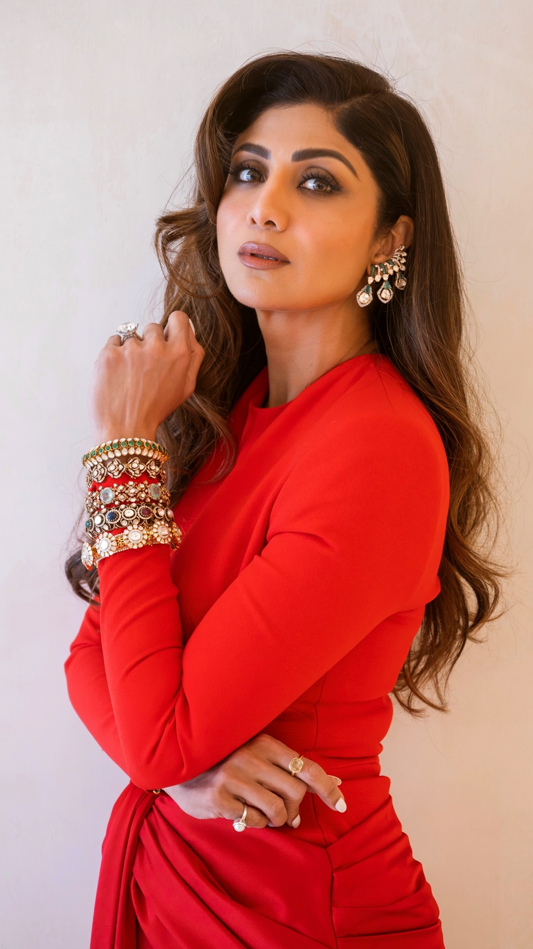 Shilpa Shetty's Recent Photoshoot - Jewellery by Anmol Jewellers combines statement earrings with layered bangles, introducing texture and brilliance against the uninterrupted red palette.