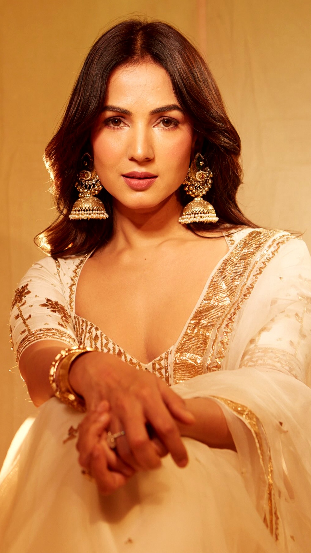 Sonal Chauhan's Recent Photoshoot - Warm-toned makeup echoes the ivory-and-gold styling, with defined eyes, softly flushed cheeks and a muted rosy lip keeping the beauty look polished.