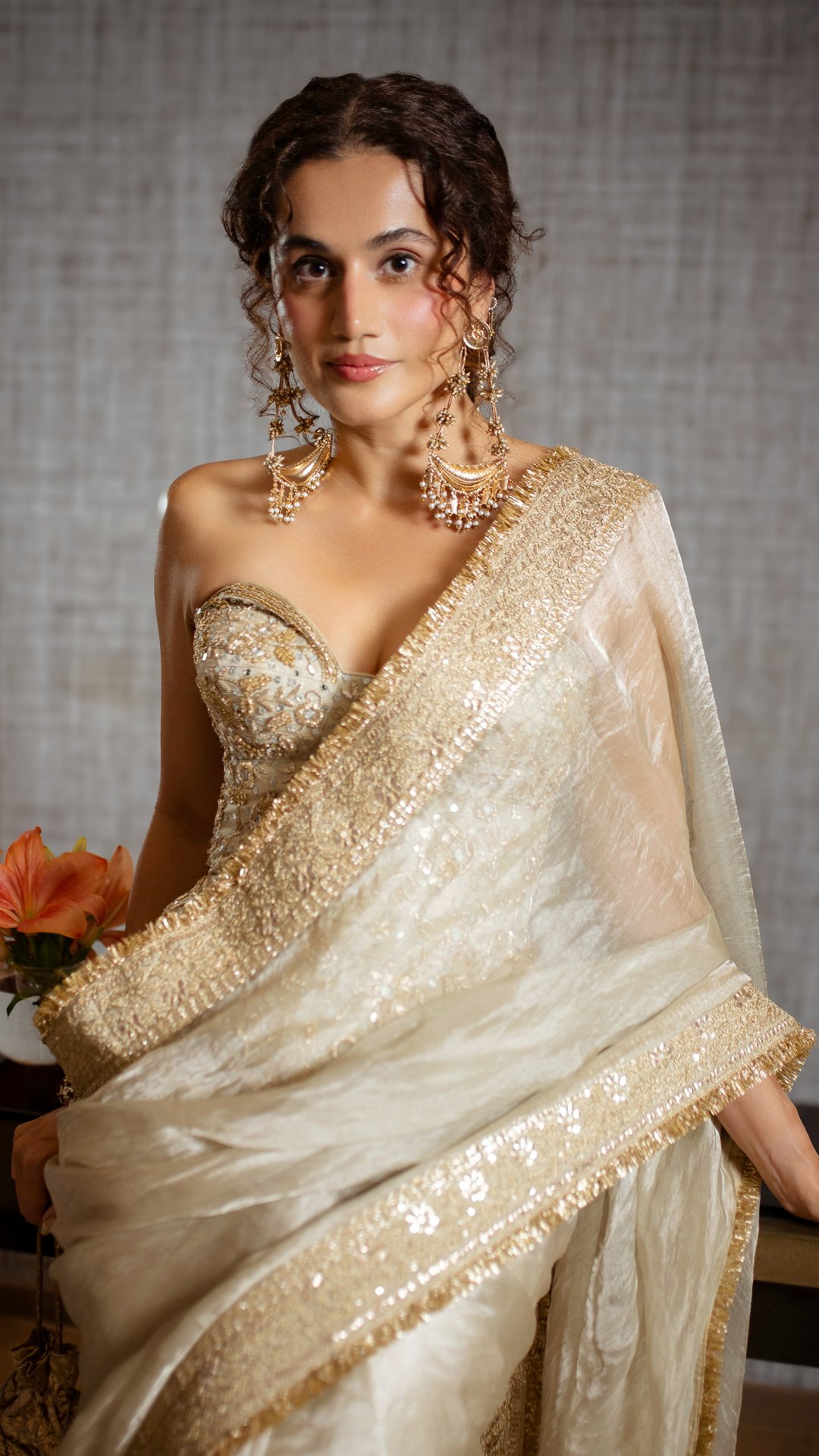 Taapsee Pannu's Recent Photoshoot - A heavily embellished strapless corseted blouse featuring a curved sweetheart neckline introduces crisp structural tailoring to the soft saree drape.