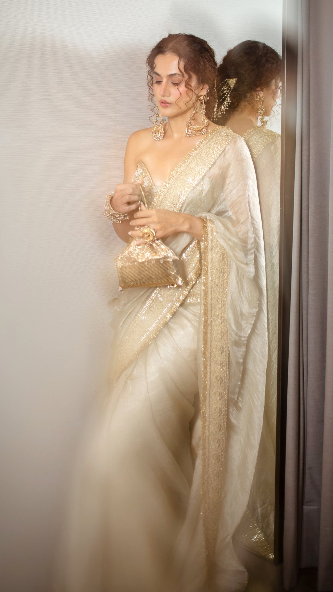 Taapsee Pannu's Recent Photoshoot - Photographer Subhro Das captures the delicate sheen of the fabric and intricate zardozi details under warm, focused indoor lighting.